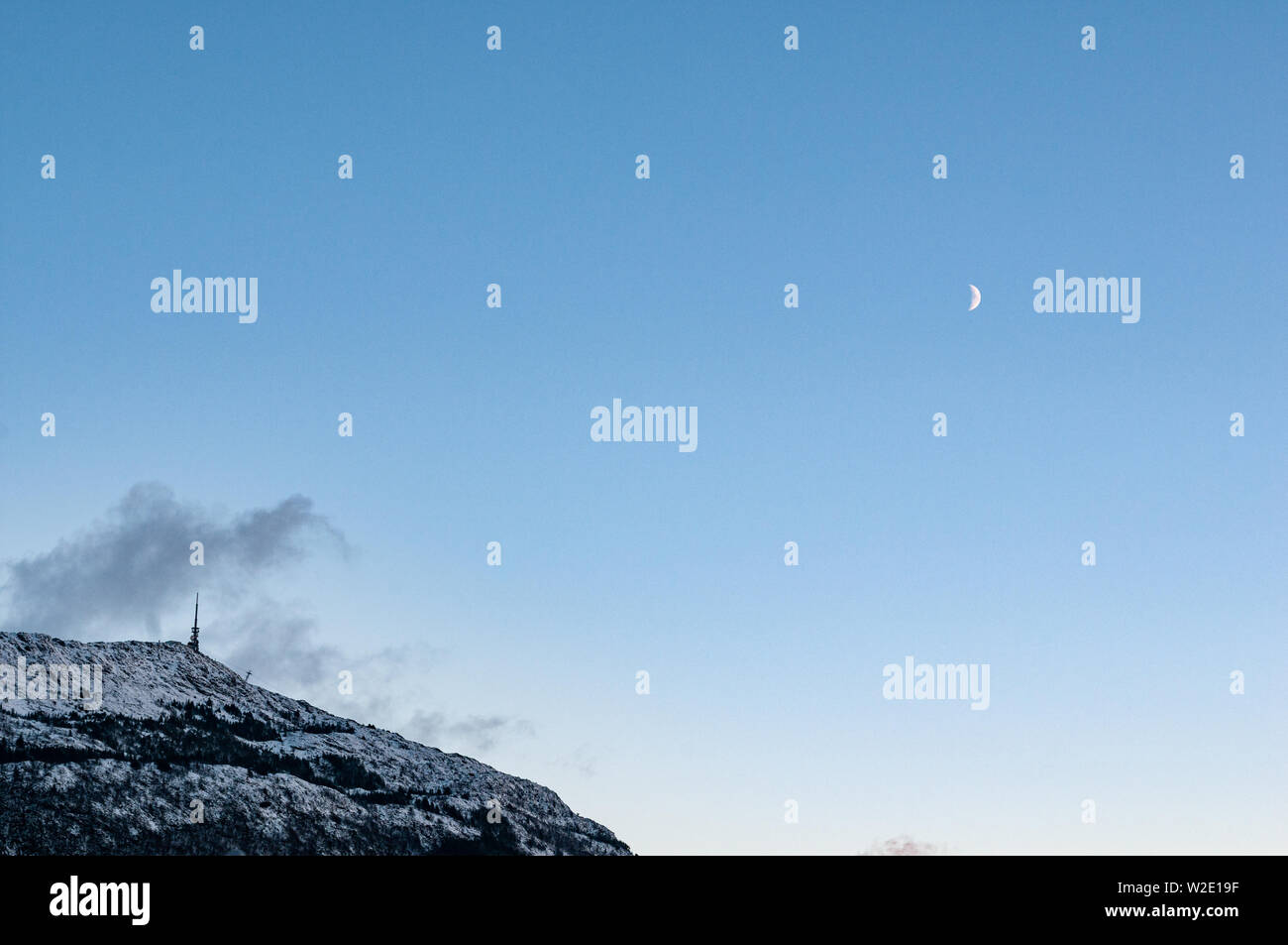 Mount Ulriken im Winter mit einem Halbmond. Bergen, Norwegen Stockfoto