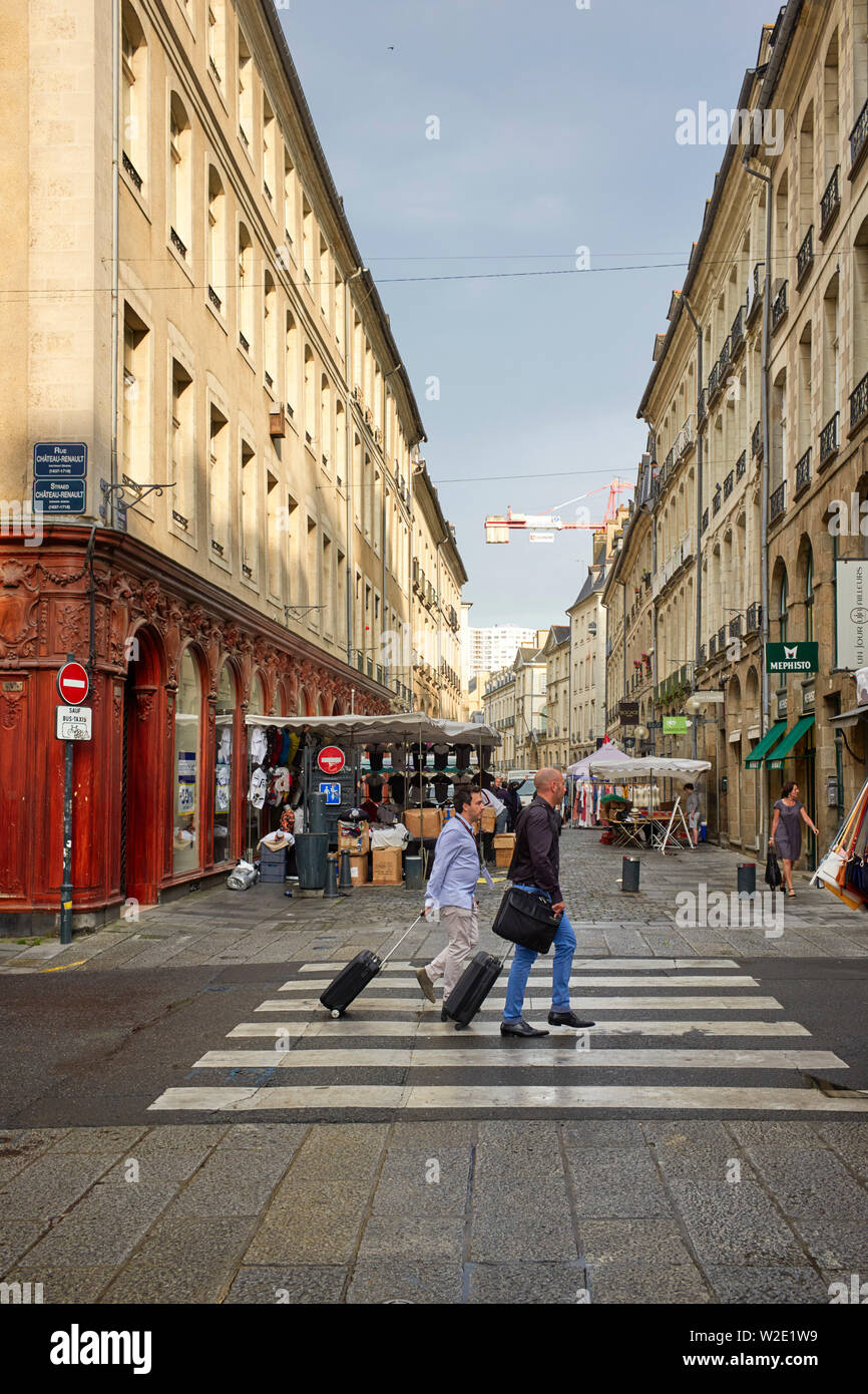 Zwei Männer mit Übernachtung Taschen zu Fuß gehen wie Marktstände werden am Tag der Umsatz von Rennes, der Hauptstadt der Bretagne, Frankreich Stockfoto