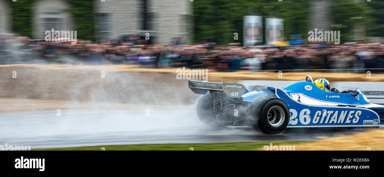 Spray fliegt von der Rückseite eines klassischen Ligier Formel 1 Rennwagen während einer nassen Morgen in Goodwood Festival der Geschwindigkeit 2019 Stockfoto