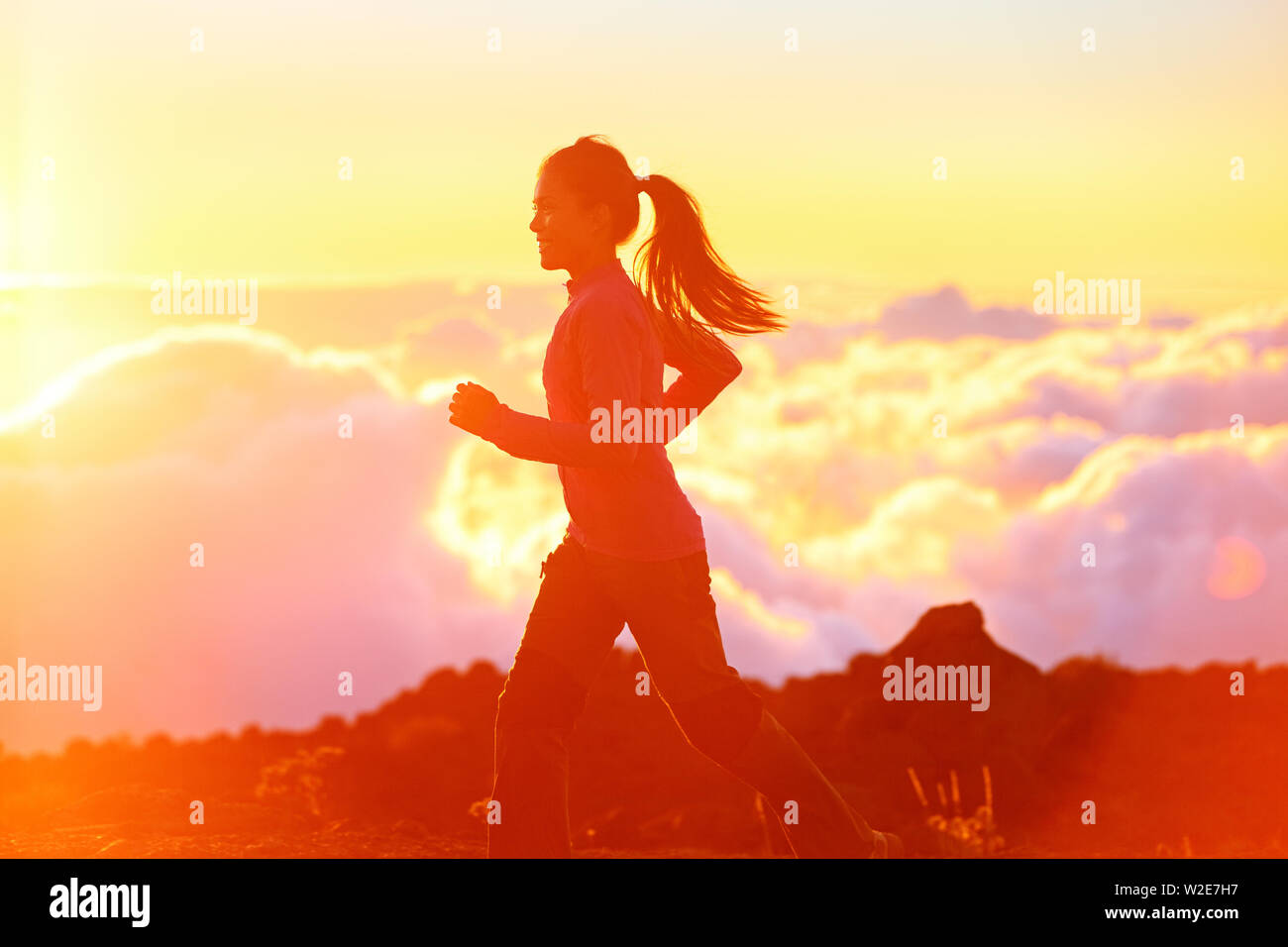 Running-Frau Läufer joggen bei Sonnenuntergang. Fitness spot Mädchen Ausbildung in sonniger Sonnenschein mit Flare und Sun Glow. Bestrebungen workout Bild mit asiatischen Jogger. Stockfoto