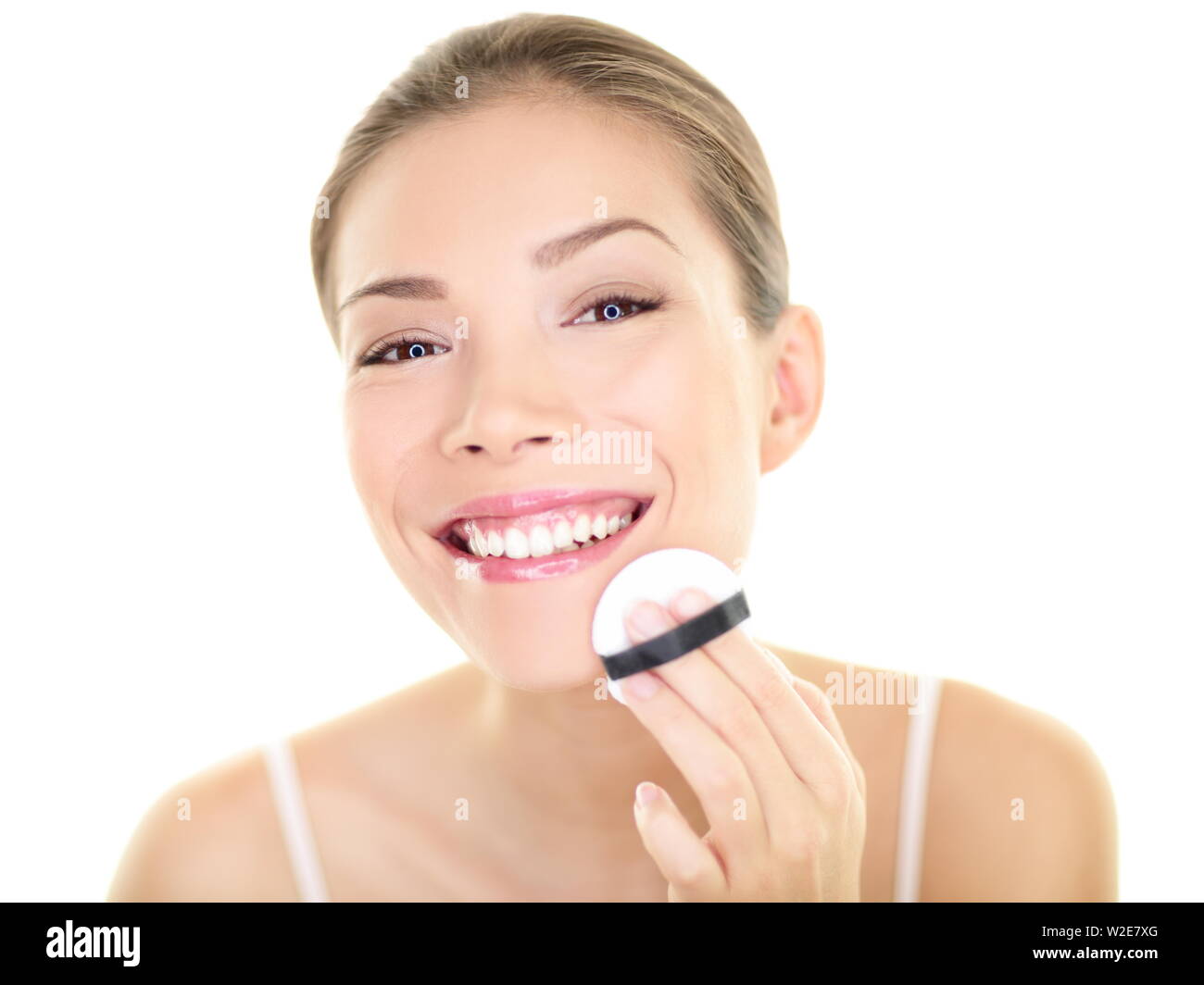 Make-up Beauty asiatische Frau Anwendung Powder Foundation auf dem Gesicht. Schöne gesunde Hautpflege Mädchen, machen sich bereit, die in den Außenspiegel auf weißem Hintergrund. Asiatische kaukasischen Modell. Stockfoto