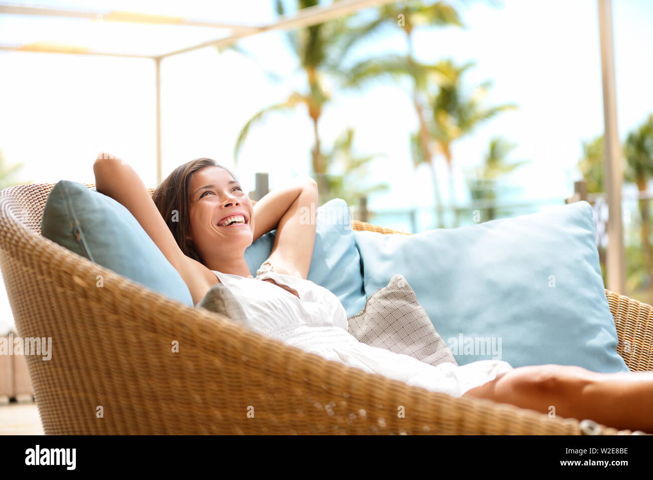 Sofa Frau entspannend genießen Luxus lifestyle outdoor Tag träumen und Denken auf der Suche gerne lächelt fröhlich. Schöne junge multikulturelle Asiatischen Kaukasischen weibliche model in ihren 20ern. Stockfoto