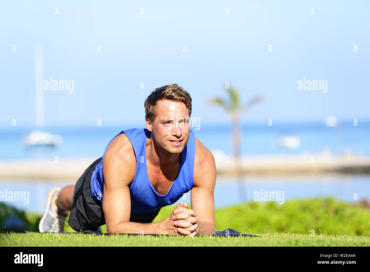 Plank core Übung. Fitness mensch Ausbildung aus seinem Mittelteil Kern Muskeln arbeiten. Passen männlich Fitness Instructor Beplankung außerhalb trainieren im Sommer auf Gras. Stockfoto