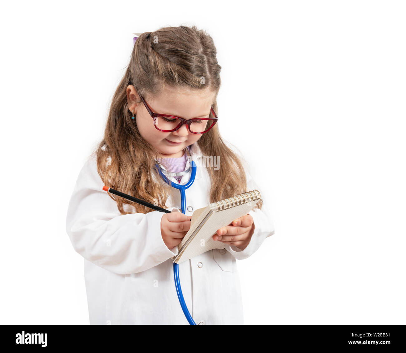 Kleine süße Mädchen in Doktor Kostüm Holding sthetoscope am Schwarzen Brett Stockfoto
