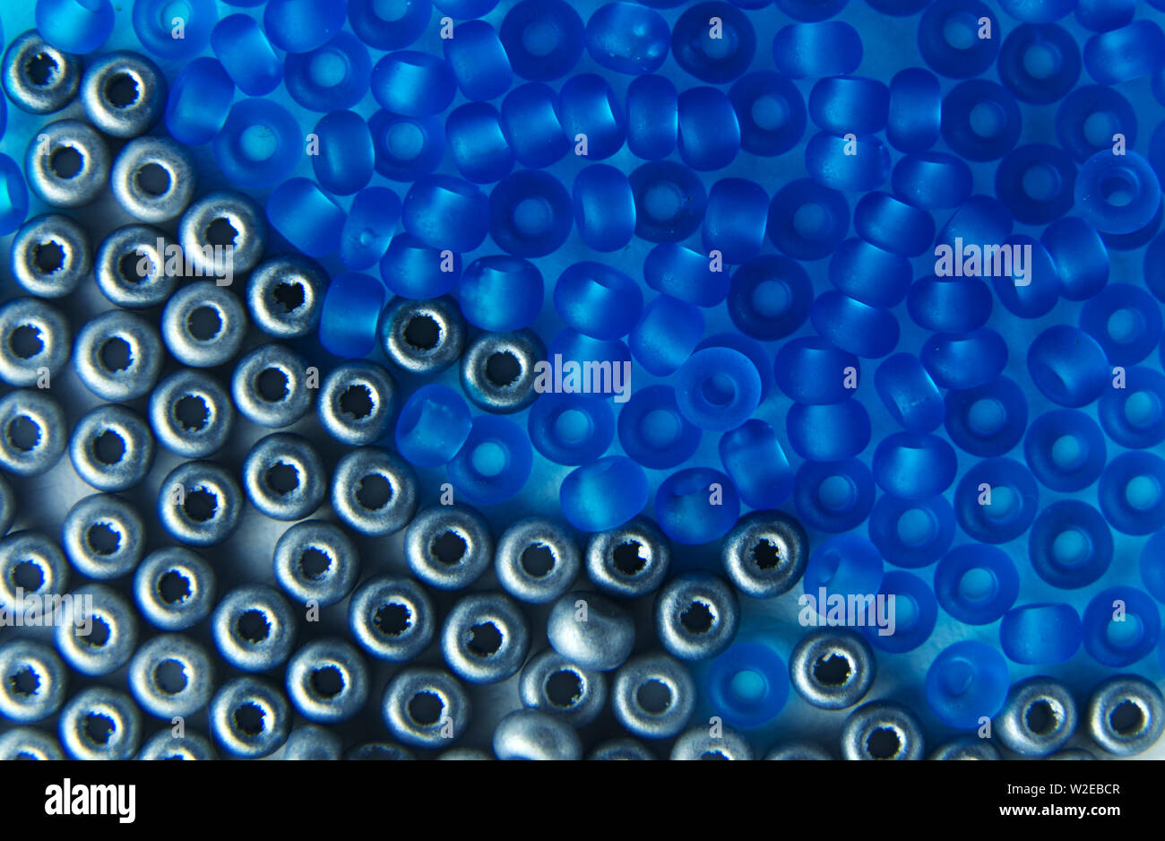 Nahaufnahme des silberfarbenen und blauen Glasperlen auf einer Platte Stockfoto