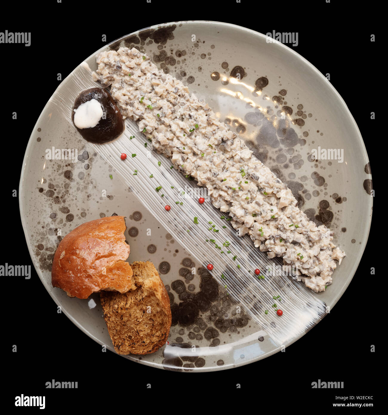 Mushroom caviar auf unebenen handgefertigten Teller, Nordische Küche, auf Schwarz mit Freistellungspfad isoliert Stockfoto