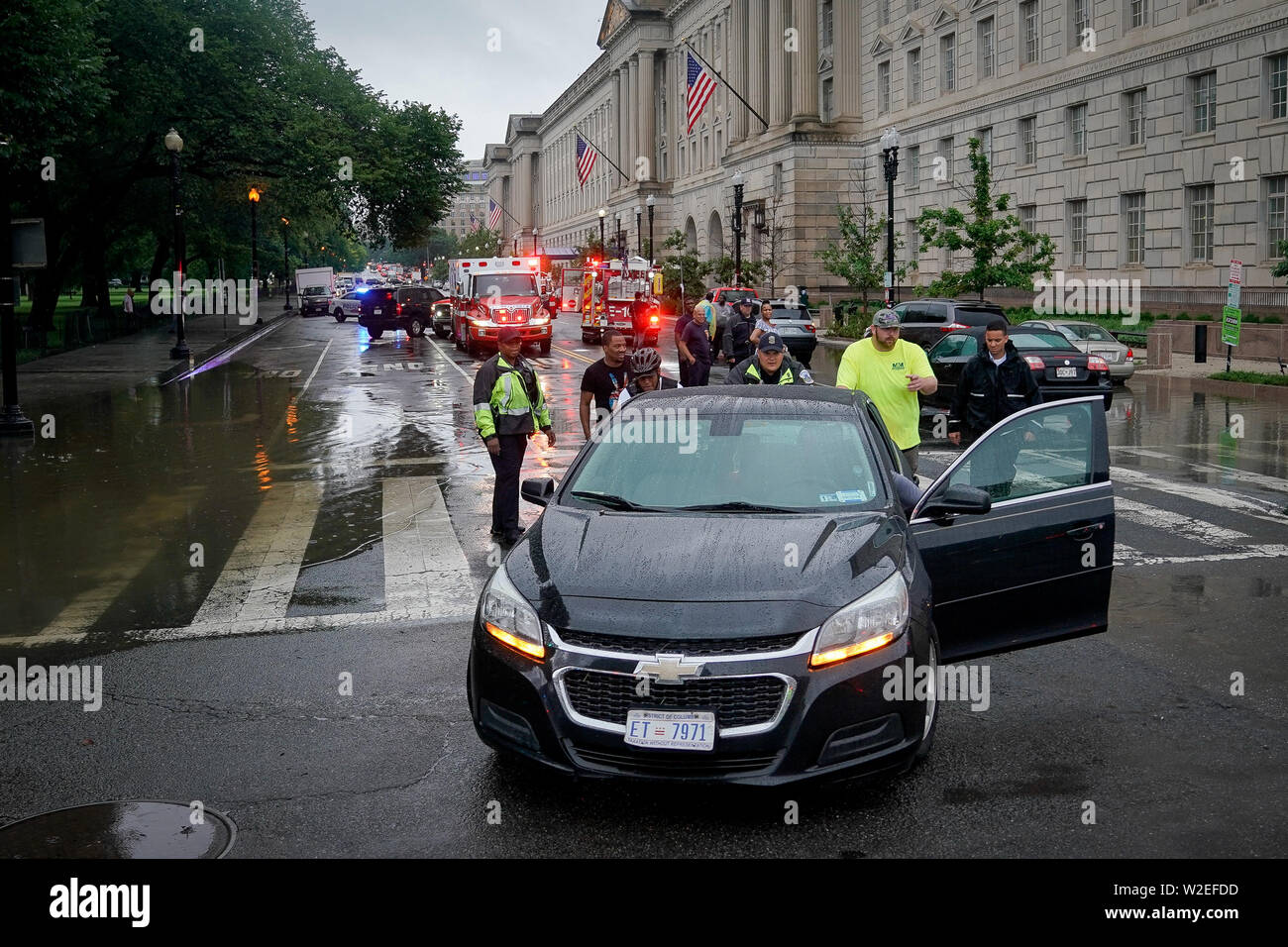 Juli 8, 2019 - Washington, DC, USA - Feuerwehr und Polizei Beamten gestrandeten Autofahrer, nachdem sie in Wasser bei einer flutartigen Überschwemmung auf Verfassung Ave fuhr, an der 13. Straße, in Washington, DC, Montag, 8. Juli 2019. (Bild: © Bryan Woolston/ZUMA Draht) Stockfoto