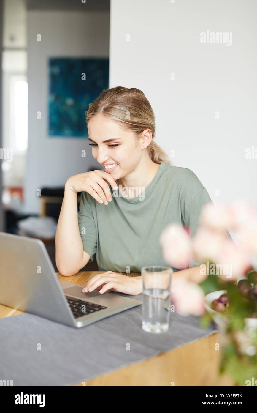 Glückliche junge Frau mit Laptop Display suchen, während sie durch Video-Chat kommunizieren. Stockfoto