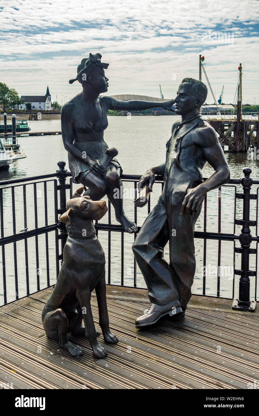CARDIFF/UK - 7. JULI: Cardiff/UK - 7. JULI: eine Bronzeskulptur "Menschen wie wir" eines jungen Paares und ihrer Dogge in Cardiff am 7. Juli 2019 Stockfoto