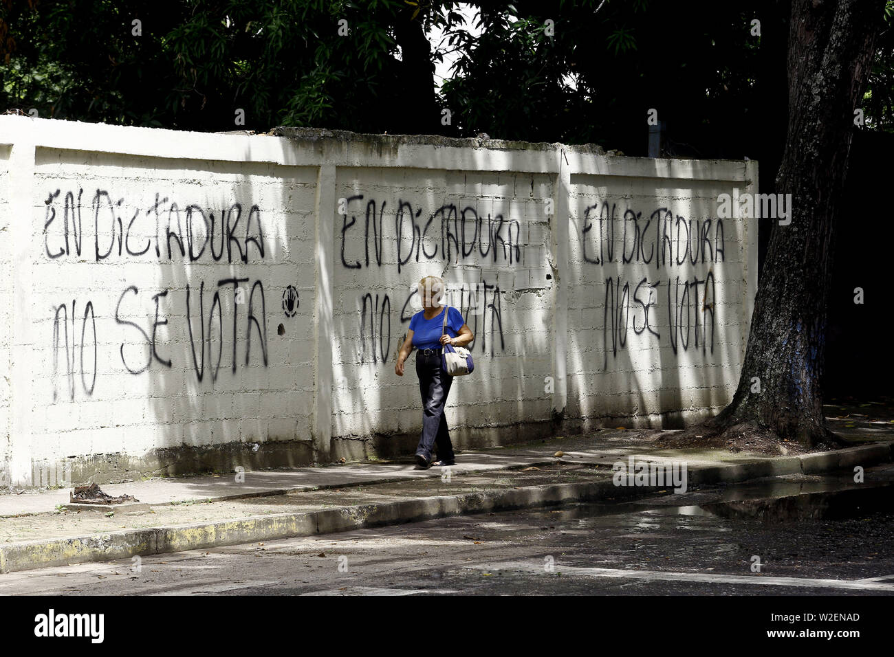 Valencia, Carabobo, Venezuela. 8. Juli, 2019. Juli 08, 2019. Eine Frau geht vor einem Graffiti Protest gegen die Wahlen, die in spanischer Sprache'', sagt In der Diktatur nicht abgestimmt ist'', in der Stadt Valencia, carabobo Zustand. Foto: Juan Carlos Hernandez Credit: Juan Carlos Hernandez/ZUMA Draht/Alamy leben Nachrichten Stockfoto