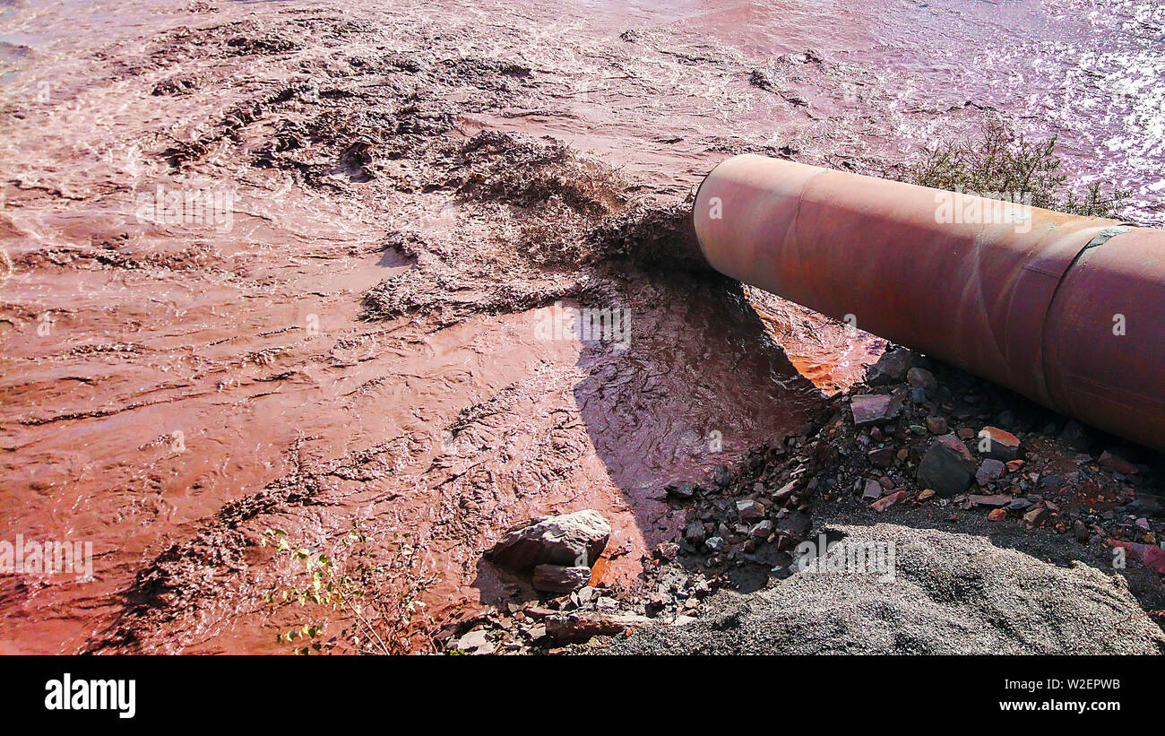 Das industrielle Abwasser wird von der Leitung in das Wasser eingeleitet. Stockfoto