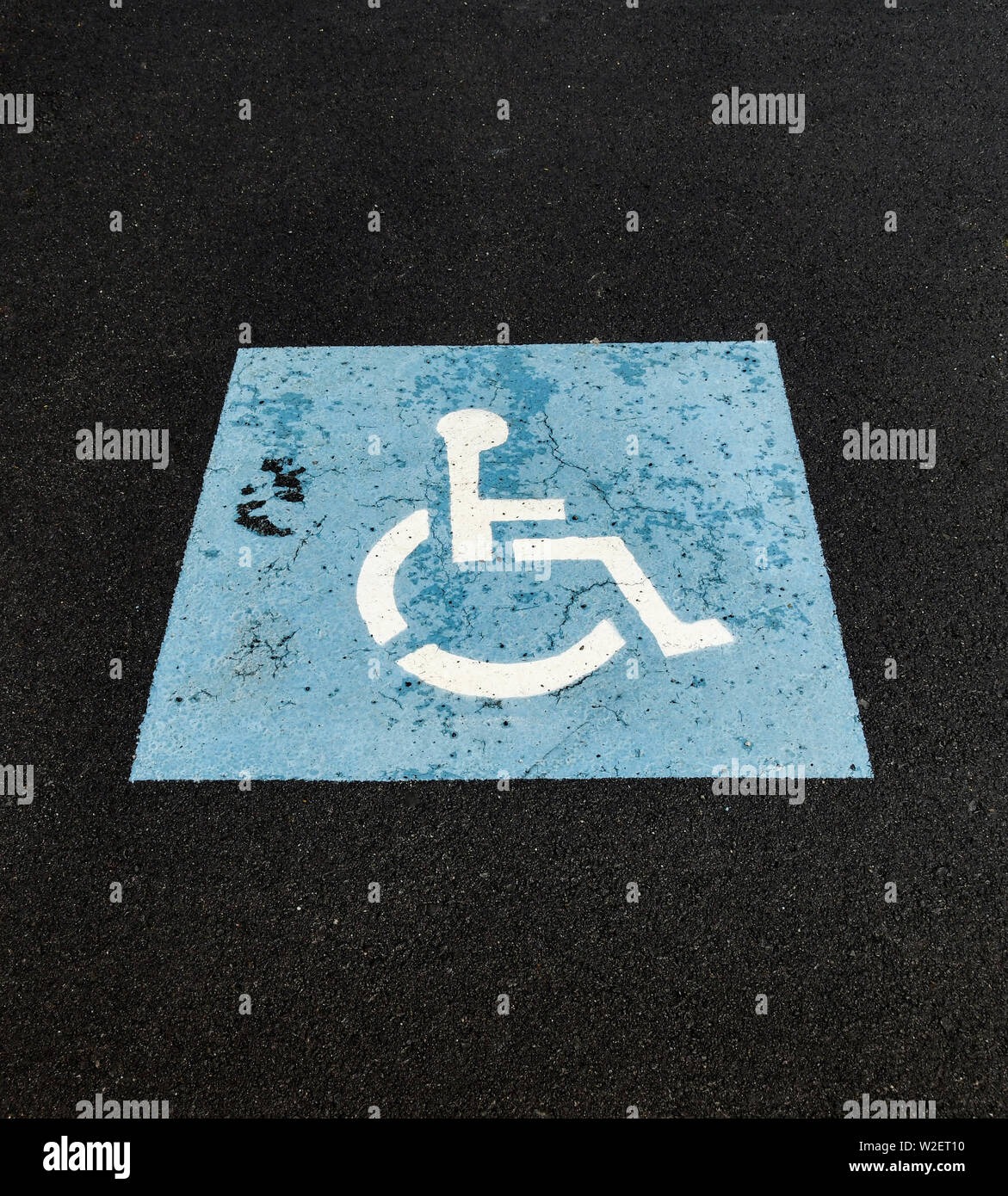 Nahaufnahme von einem Rollstuhl Symbol auf der Oberfläche auf einem Parkplatz ein Pkw Stellplatz für behinderte Personen zu bezeichnen, Stockfoto