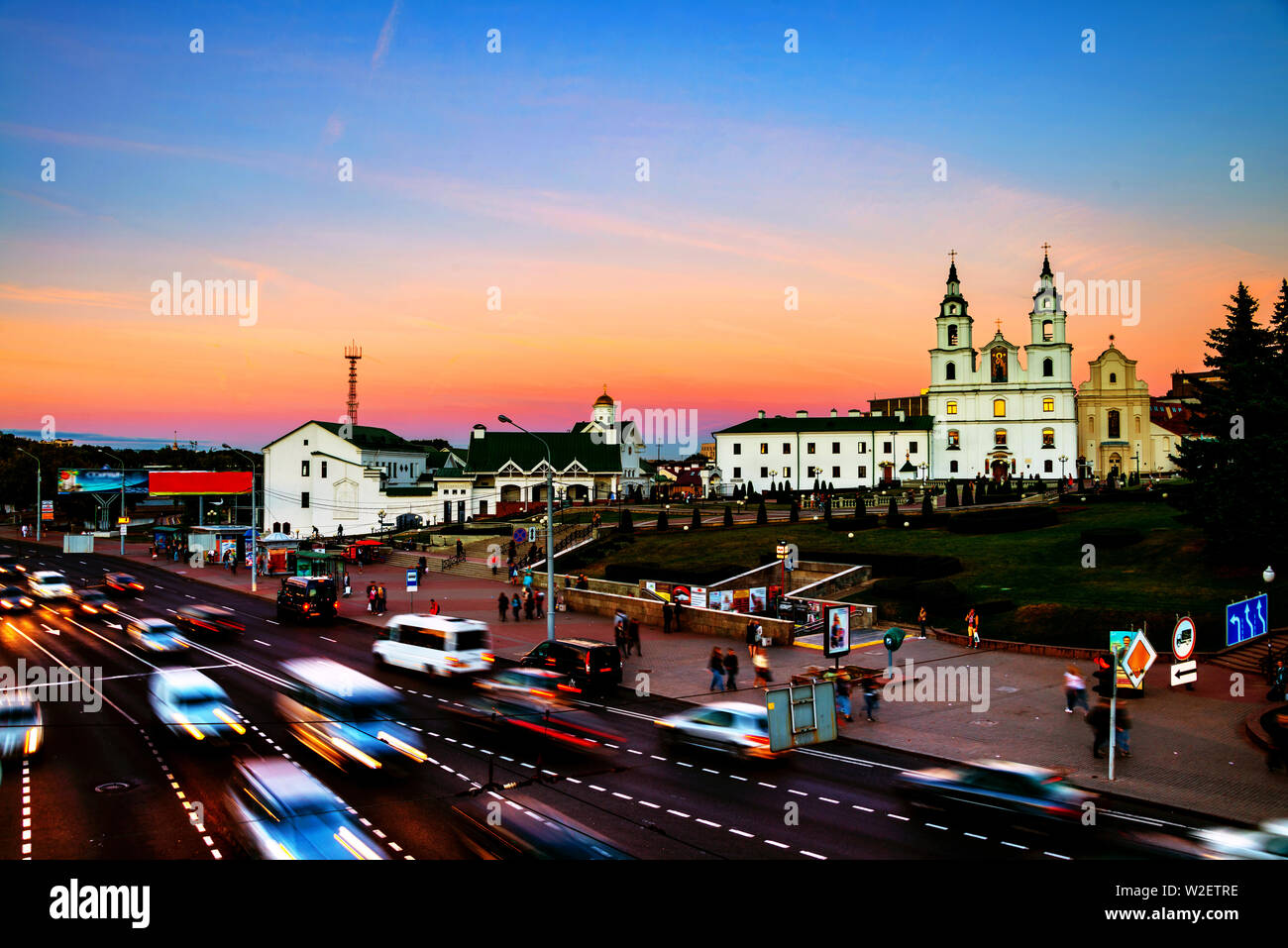 Minsk, Weißrussland. Luftaufnahme von Minsk Kathedrale mit Menschen und Verkehr. Auto trail Lichter und Sonnenuntergang Himmel. Stockfoto