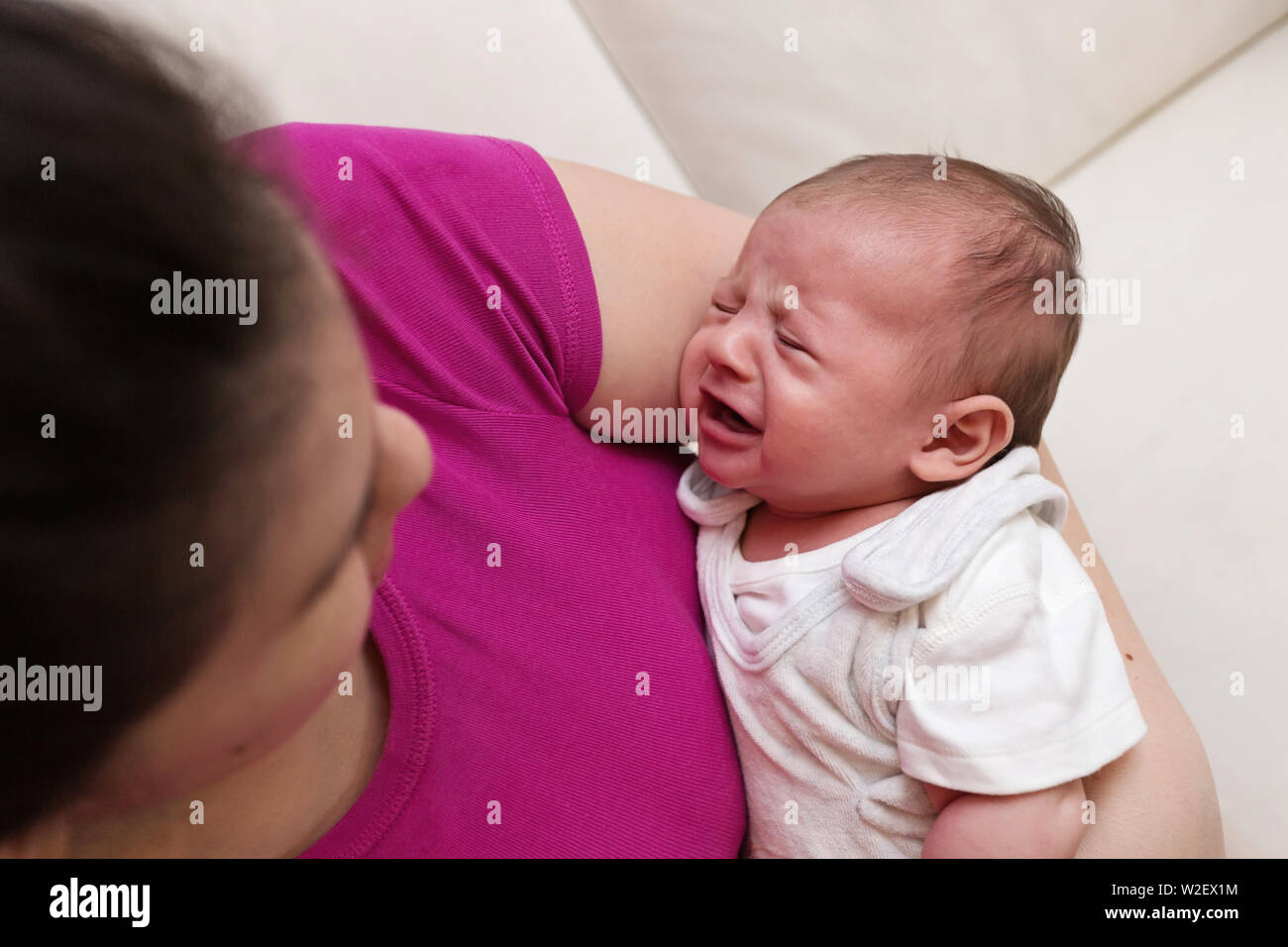 Schlaflose Mutter halten und sie trösteten Baby weinen Stockfoto