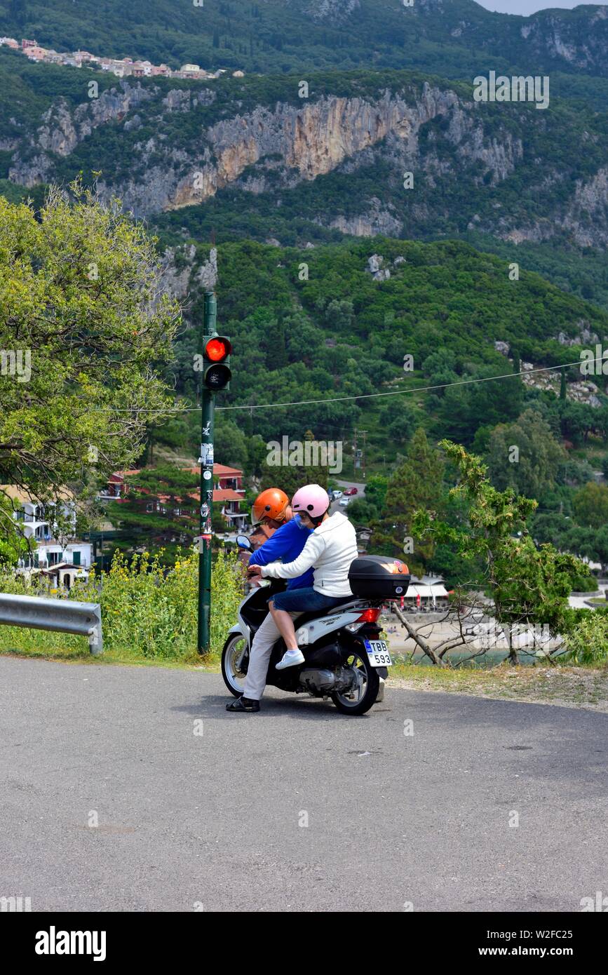 Touristische Paar auf einem Moped, am Straßenrand Ampel warten, auf dem Weg nach Paleokastritsa Kloster, Kloster Theotokos, Korfu, Griechenland Stockfoto