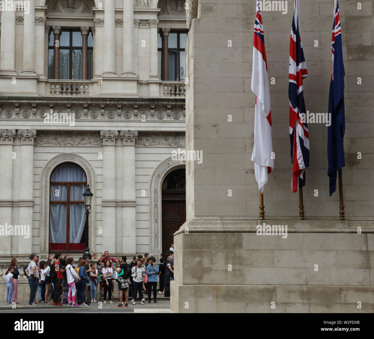 Gruppe von Touristen und ein Reiseführer in Whitehall, gegenüber dem Kriegerdenkmal an einem warmen Sommertag im Juli in London. Stockfoto