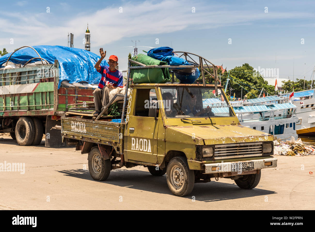 Makassar, Sulawesi, Indonesien - 28. Februar 2019: Paotere Alten Hafen. Nahaufnahme der alte beschädigt Pickup Truck mit Männern, tarps und andere Sachen Reiten am Stockfoto