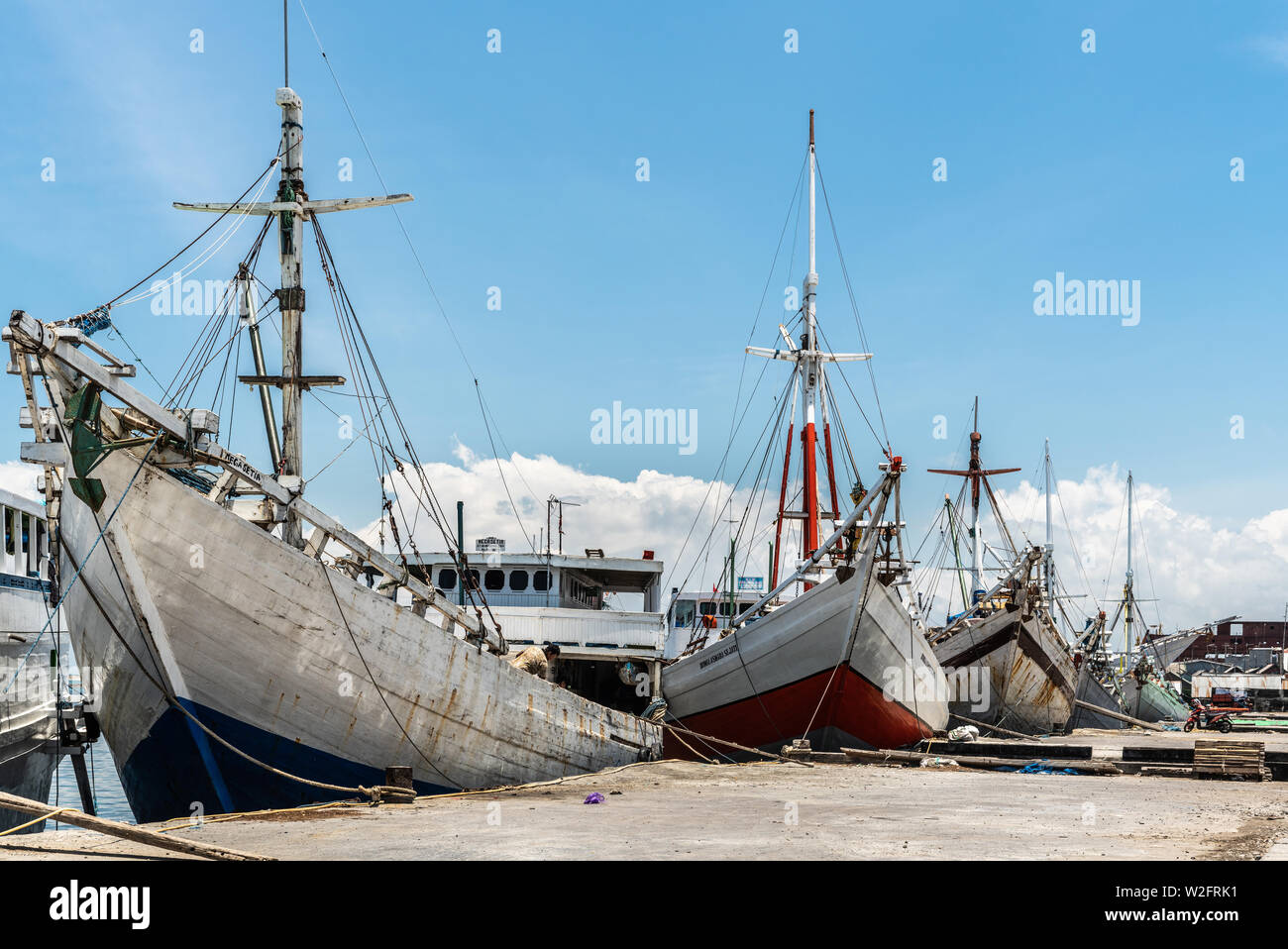 Makassar, Sulawesi, Indonesien - 28. Februar 2019: Paotere Alten Hafen. Mehrere Bögen der meist weißen Insel Transport Boote Peep über das Dock unter Blu Stockfoto