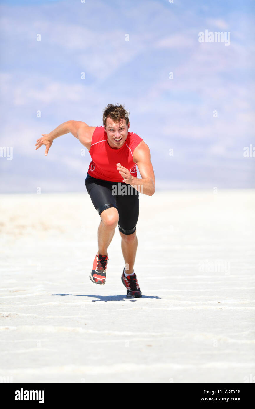 Zweiter Mann laufen Outdoor sprinten in der Wüste Natur. Passen Athlet in  schnellen Sprint mit großer Geschwindigkeit in Richtung Kamera. Männliche  fitness Modell Ausbildung und arbeiten sie in erstaunlichen extreme  Landschaft der