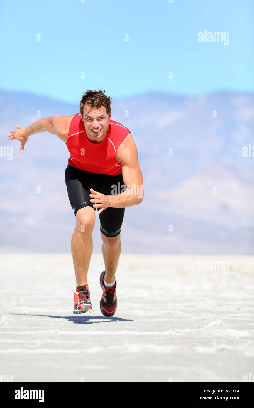 Laufender Mann - Läufer sprintete in der Wüste Natur. Passen Athlet in schnellen Sprint mit großer Geschwindigkeit in Richtung Kamera. Männliche fitness Modell in erstaunlichen extreme Landschaft der Wüste. Stockfoto