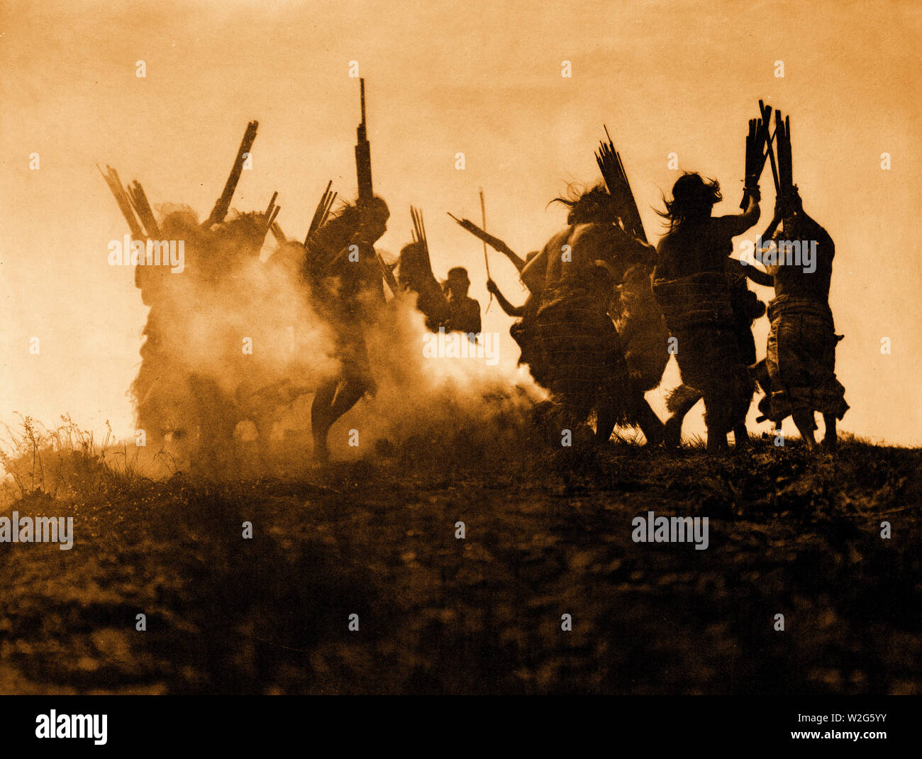 Mehrere Kwakiutl Leute tanzen im Kreis um ein Feuer das Rauchen, in einer Bemühung, einen Himmel Kreatur, die Sie glauben, dass der Mond, dadurch zu niesen es Degorgieren verschlucken verursachen. Stockfoto