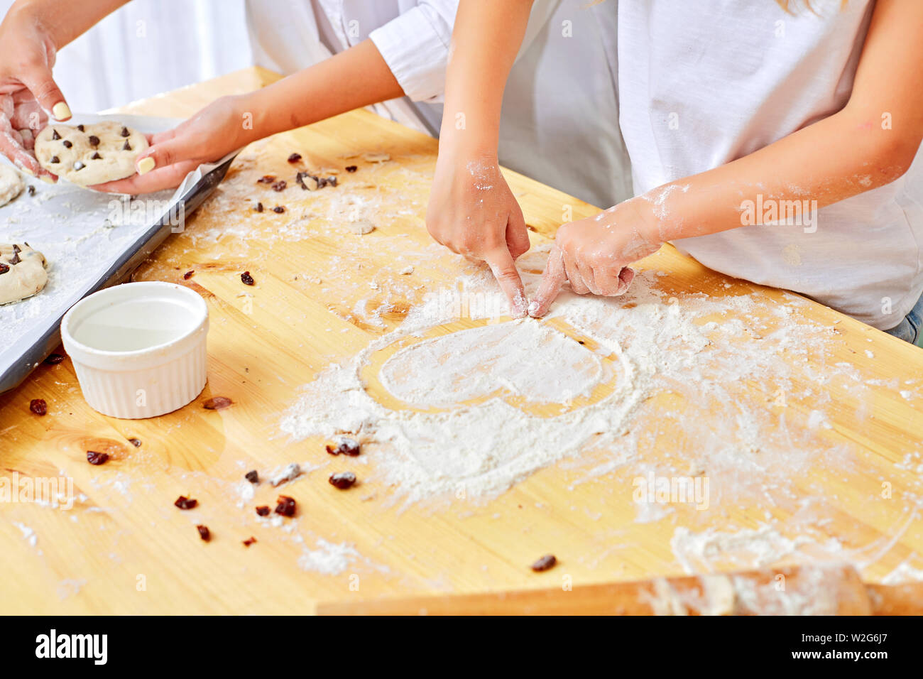 7/8 Bild einer attraktiven jungen Frau und ihrer kleinen niedlichen Tochter Kochen in der Küche. Gemeinsam Spaß haben, Kuchen und Kekse. Seite vie Stockfoto