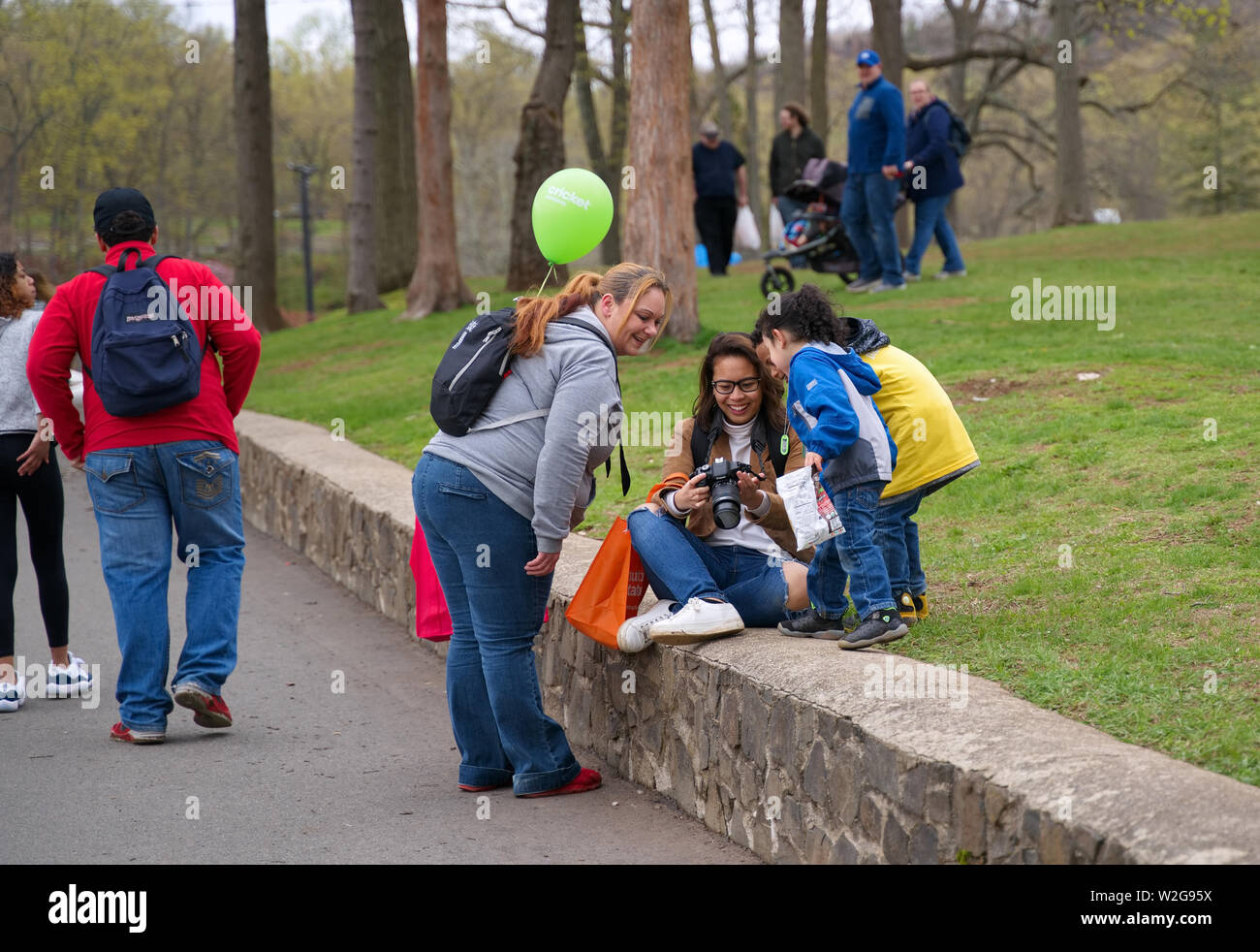 Meriden, CT USA. Apr 2019. Narzissenfest. Junge asiatisch-amerikanische Fotografin Interaktion mit einem Multi Rasse Familie. Stockfoto