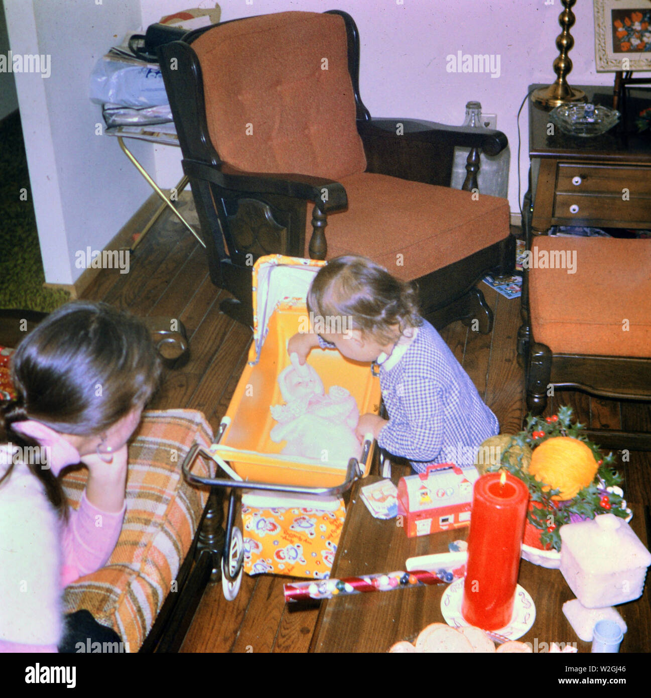 Kleine Mädchen spielen mit Ihrem baby doll Weihnachtsgeschenk Ca. 1975 Stockfoto