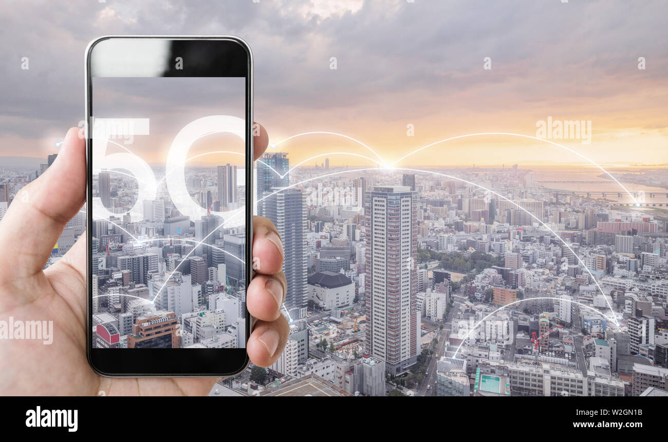 Hand mit Smart Phone und drahtlose Netzwerk Anschlusstechnik in der Stadt, mit 5G-Internet Networking Stockfoto