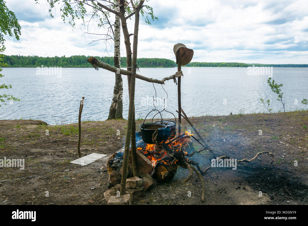 Touristische Lagerfeuer mit zwei großen schwarzen Kessel am Ufer eines großen Flusses, Russland. Stockfoto