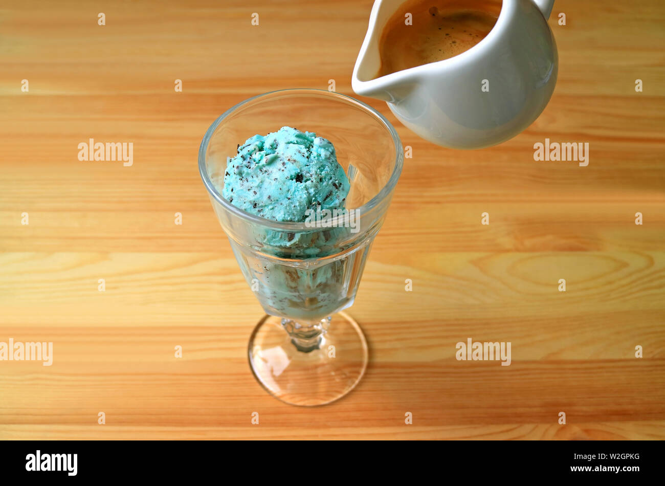 Glas mint Chocolate Chip Eis mit einem Espresso für Affogato auf hölzernen Tisch serviert Stockfoto