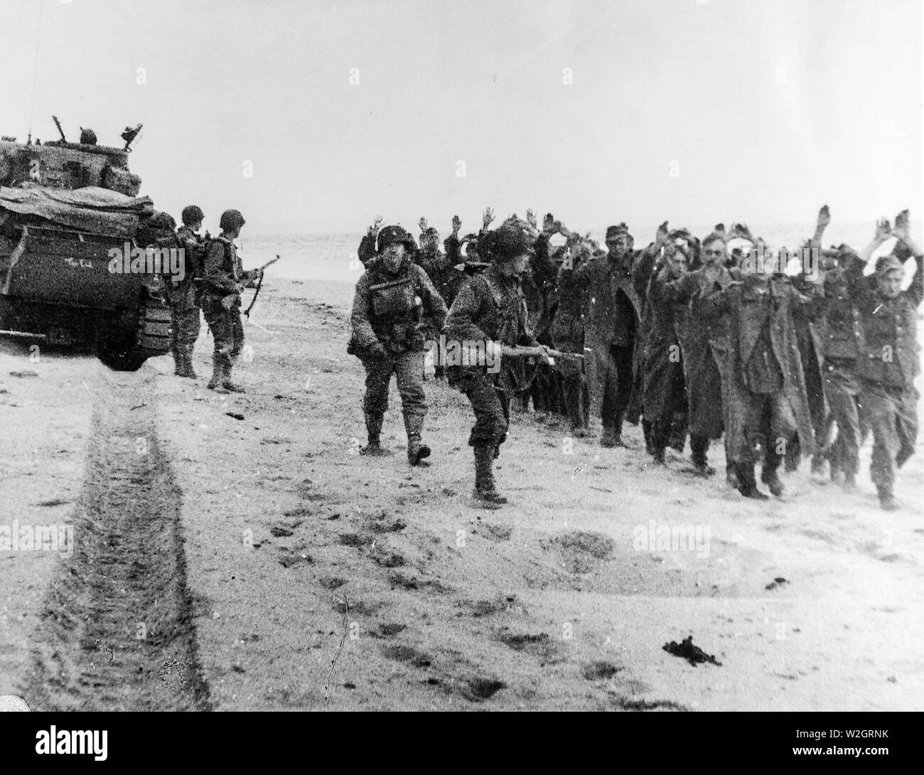 [CAPTION] Original amerikanische Soldaten März eine Gruppe von deutschen Gefangenen zusammen einen Brückenkopf in Nordfrankreich, wonach Sie nach England geschickt werden. Stockfoto