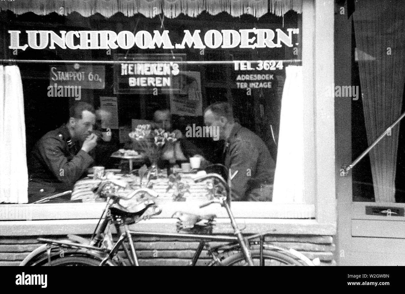 Deutsche Soldaten an einem modernen Speisesaal in der Long Street (langestraat) 1941 in Essen Stockfoto