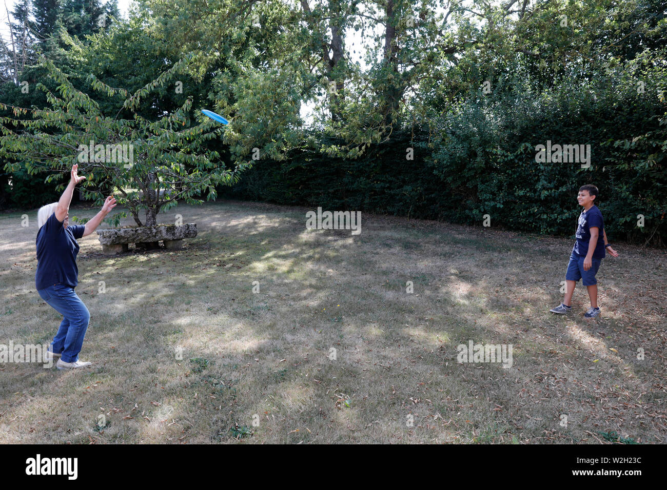 Der 12-jährige Junge spielt Frisbee mit seiner Großmutter in Bosc-Renoult, Frankreich. Stockfoto Der 12-jährige Junge spielt Frisbee mit seiner Großmutter in Bosc-Renoult, Frankreich. Stockfoto