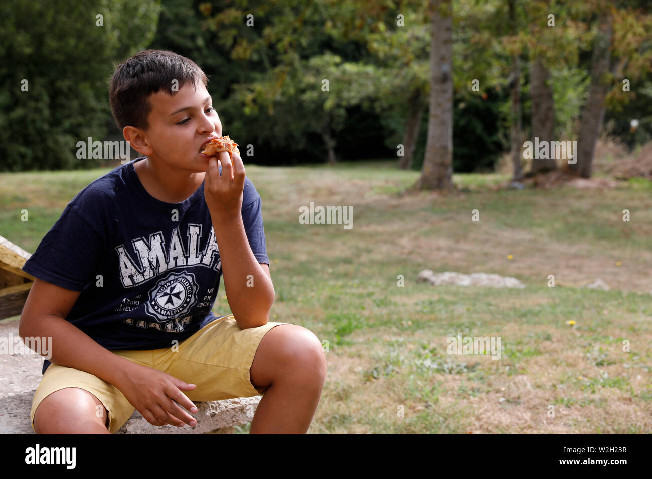 12-jähriger Junge Essen in einem Garten in Bosc-Renoult, Frankreich. Stockfoto 12-jähriger Junge Essen in einem Garten in Bosc-Renoult, Frankreich. Stockfoto