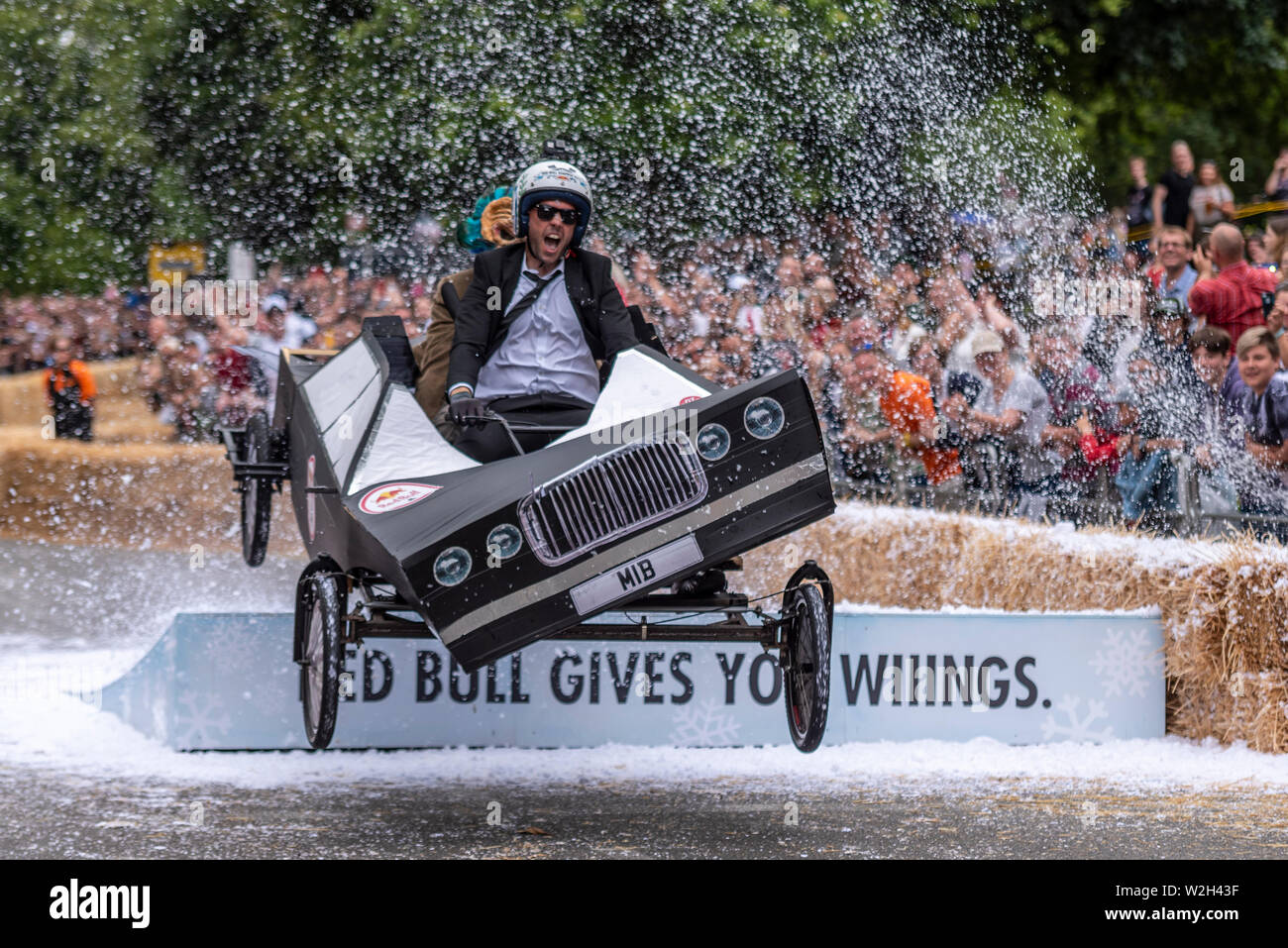 Ally Pally MIB-team Auto konkurrieren in der Red Bull Seifenkistenrennen 2019 an Alexandra Park, London, UK. Sprung über Rampe mit Menschen Stockfoto