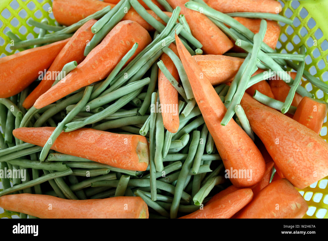 Nahaufnahme der Organischen carrotsand grüne Bohnen in einem Korb. Ha Tien. Vietnam. Stockfoto