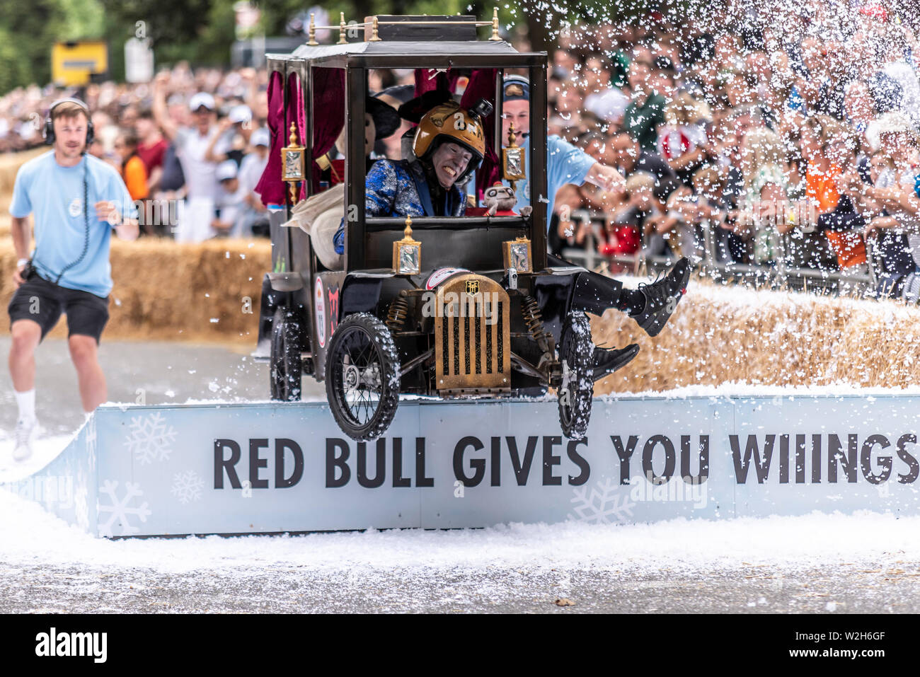 Dracs Party Bus konkurrieren in der Red Bull Seifenkistenrennen 2019 an Alexandra Park, London, UK. Sprung über Rampe mit Menschen Stockfoto