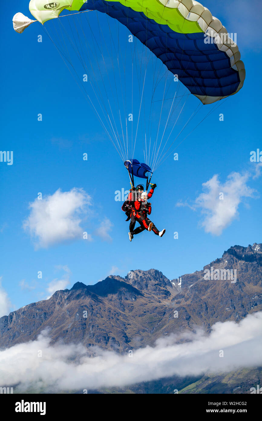 Tandem Skydivers Vorbereitung zu Landen, Queenstown, Südinsel, Neuseeland Stockfoto