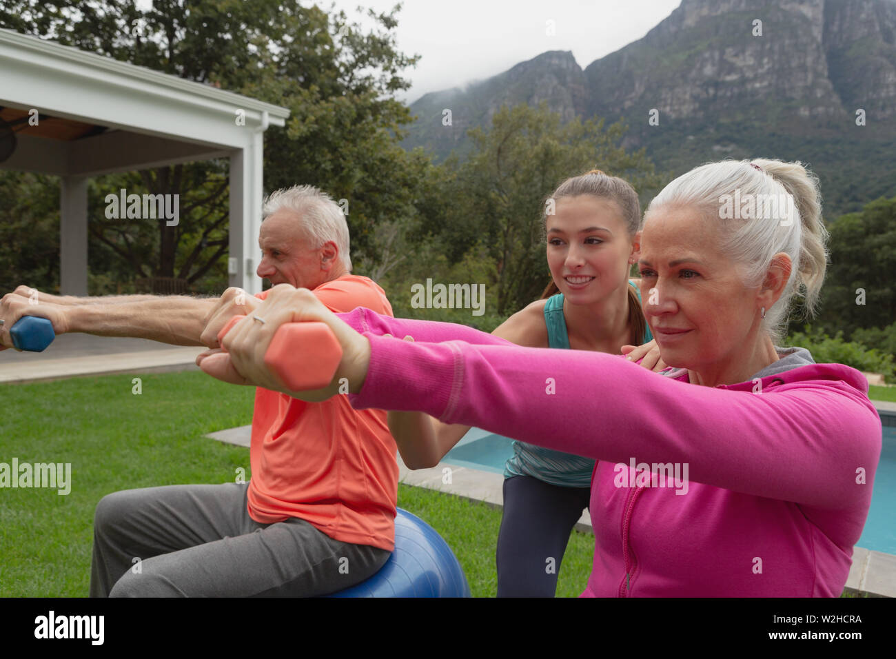 Weibliche Trainer unterstützt Active Senior Paar mit Hanteln zu trainieren Stockfoto