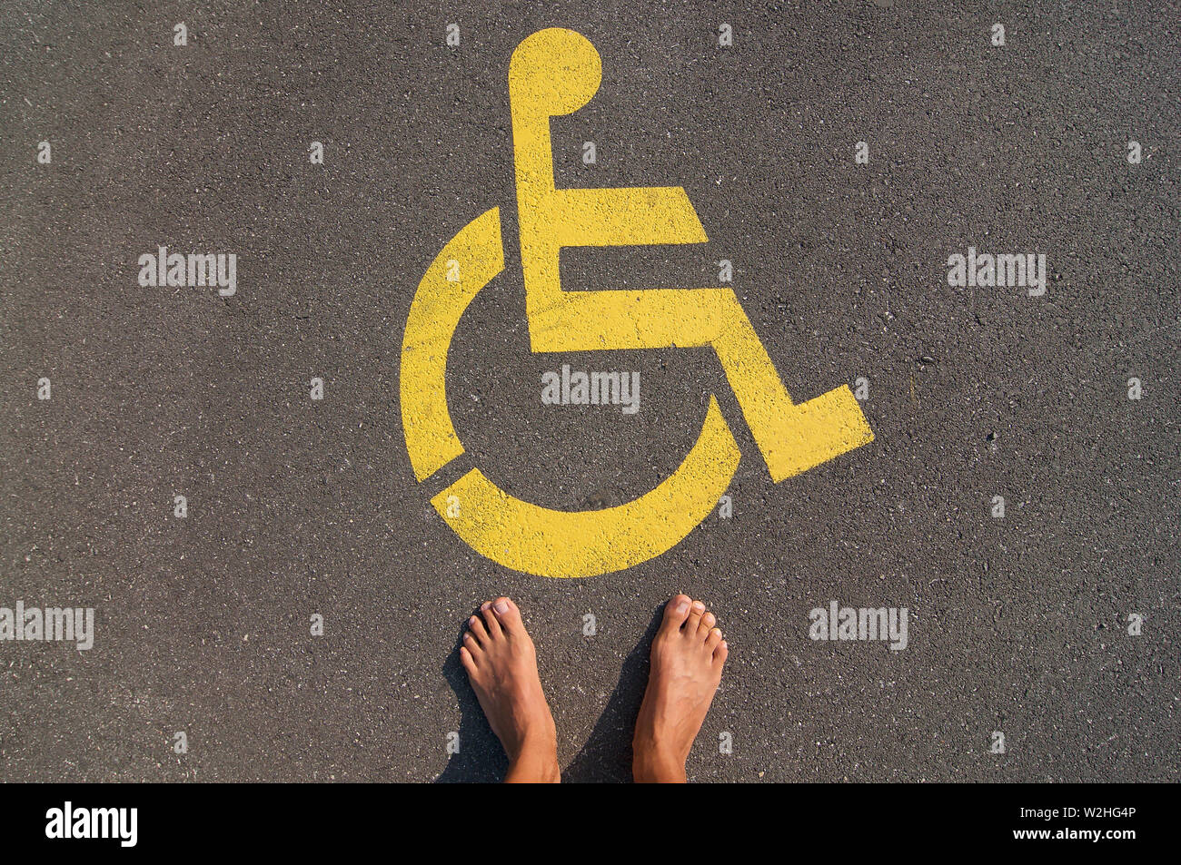 Bild der Mann, der vor einem gelben Handicap parking Sign auf dem Asphalt der Straße in brauchen, Tessin - Schweiz gezeichnet deaktivieren Stockfoto