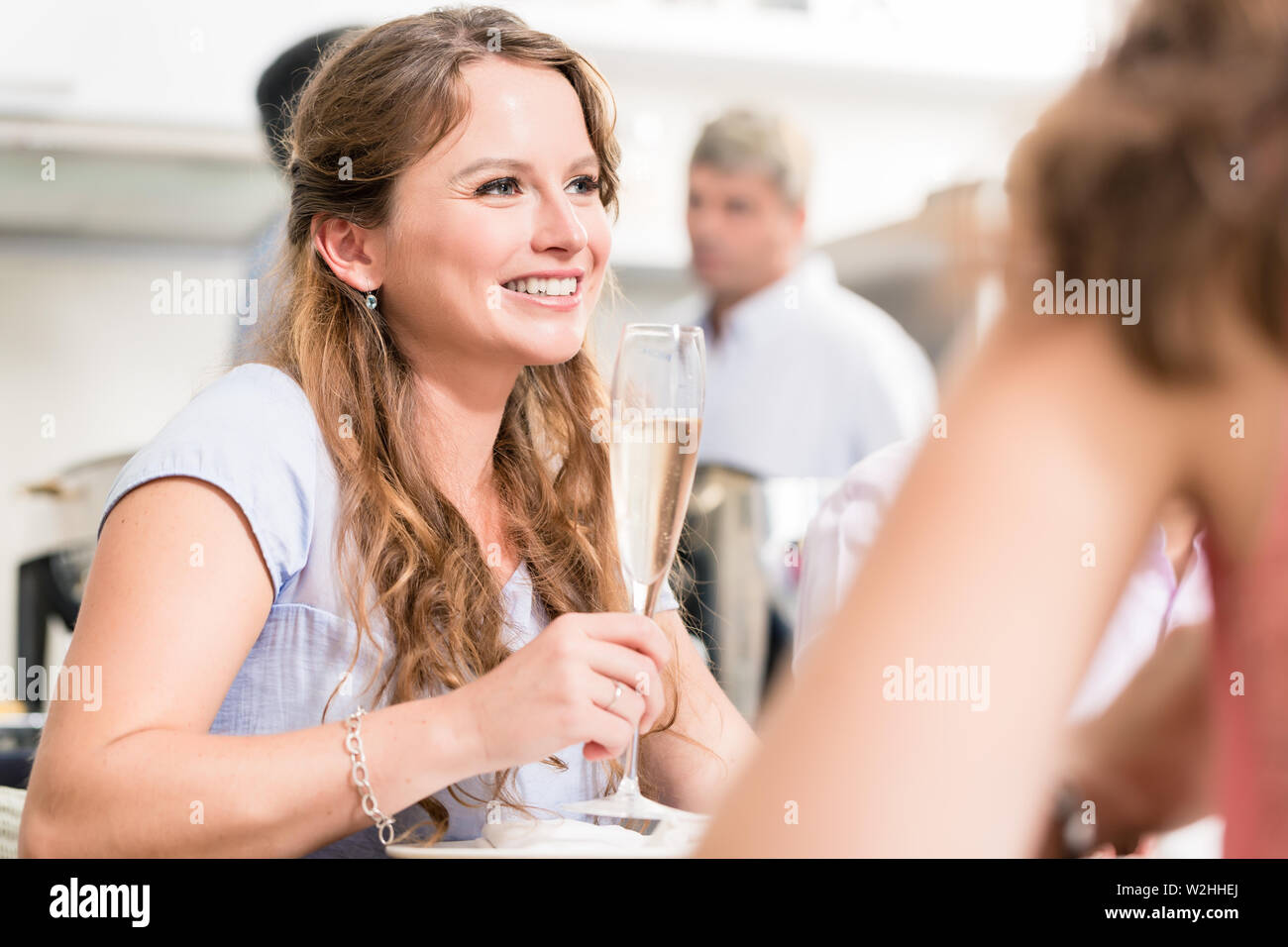 Junge Frau mit Champagner mit Freund Stockfoto