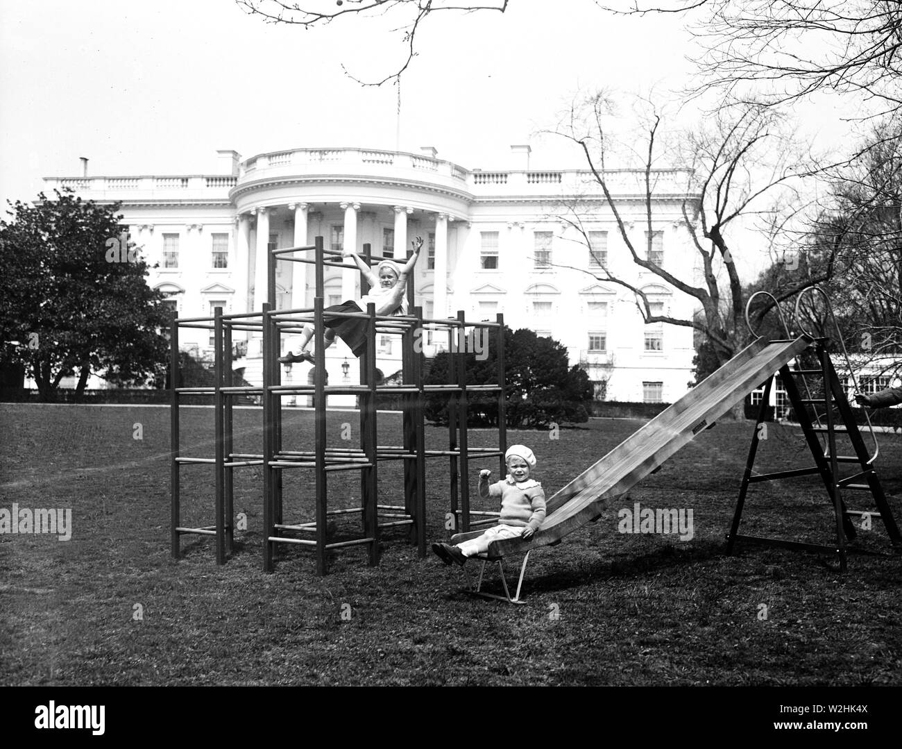Franklin D. Roosevelt - eines der ersten Fotos von der Roosevelt Enkel beim Spielen auf dem Rasen des Weißen Hauses - wenig Sistie und Buzzie Dall auf einem Spielplatz auf South Lawn Ca. 1933 Stockfoto