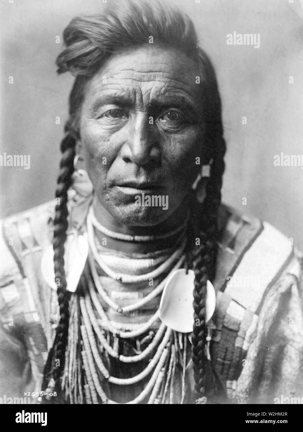 Edward S. Curtis Native American Indians - [Schlag auf seinen Kopf, Crow Indian, Montana Ca. 1908 Stockfoto