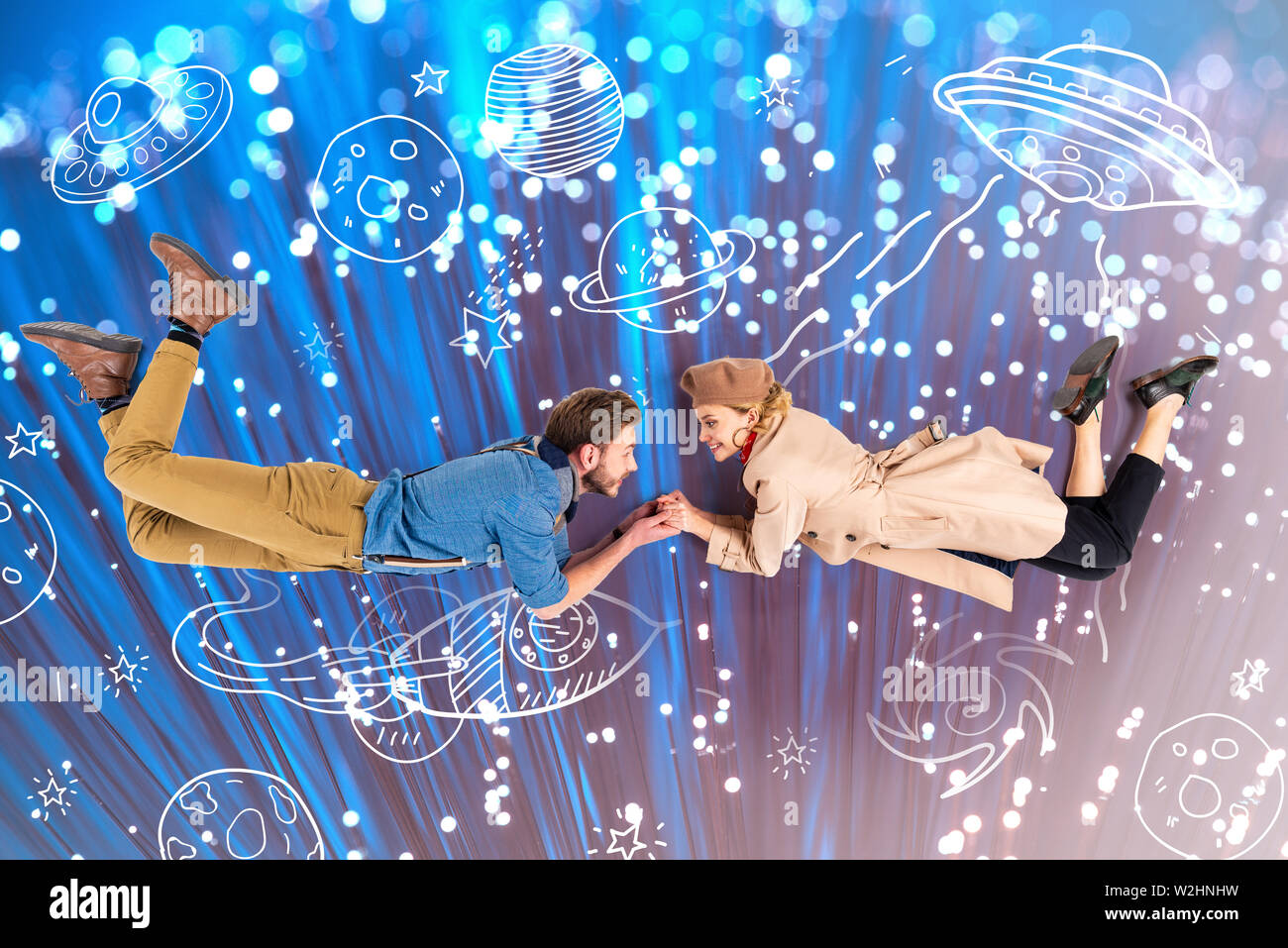 Elegantes Paar halten sich an den Händen und fliegen zusammen mit Abbildung und funkelt auf Hintergrund Stockfoto