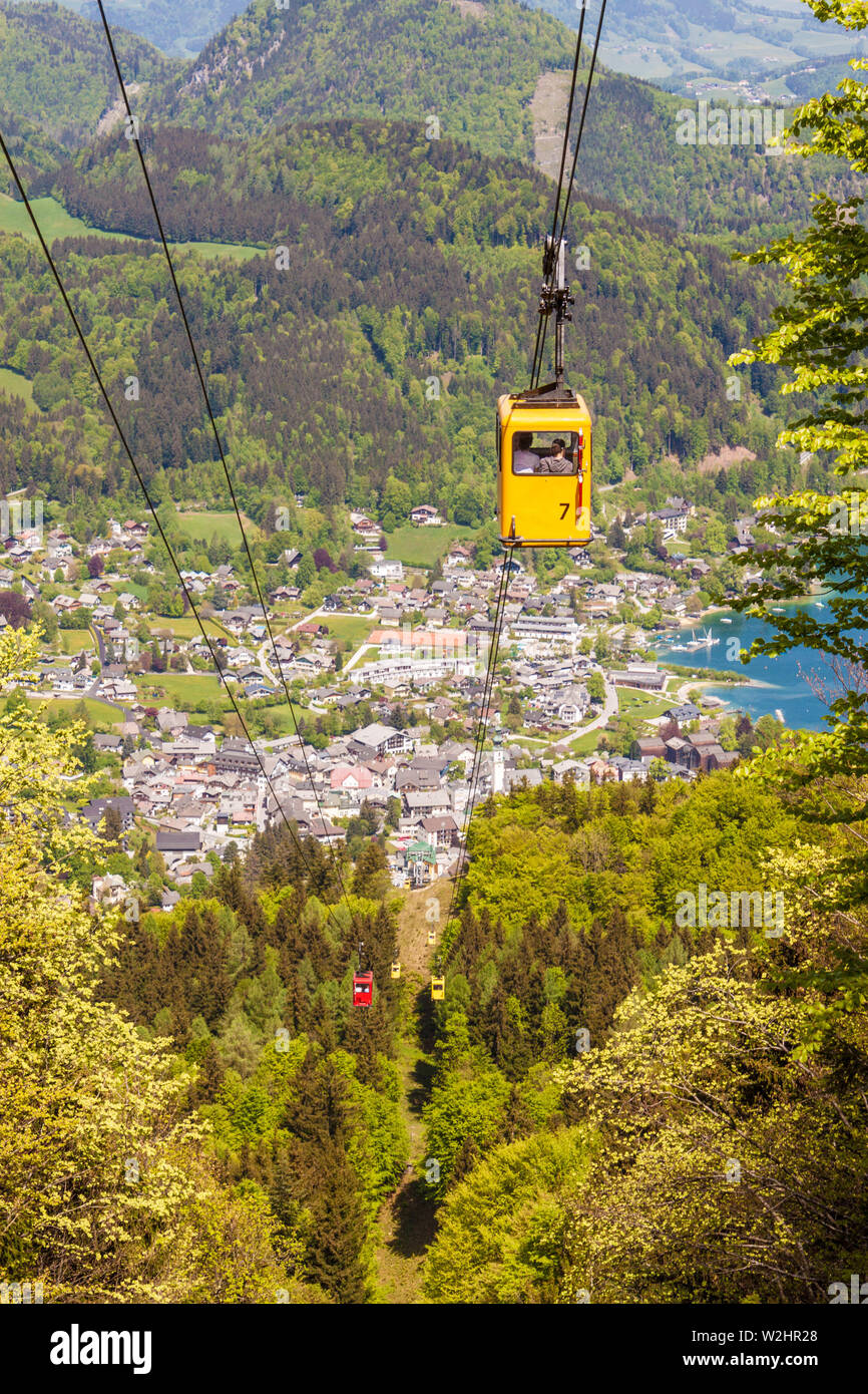 Gelbe Gondel der Seilbahn Zwoelferhorn (Seilbahn) Reisen nach oben und unten alpine Peak mit einem Blick auf den Ort St. Gilgen und den Wolfgangsee See Stockfoto