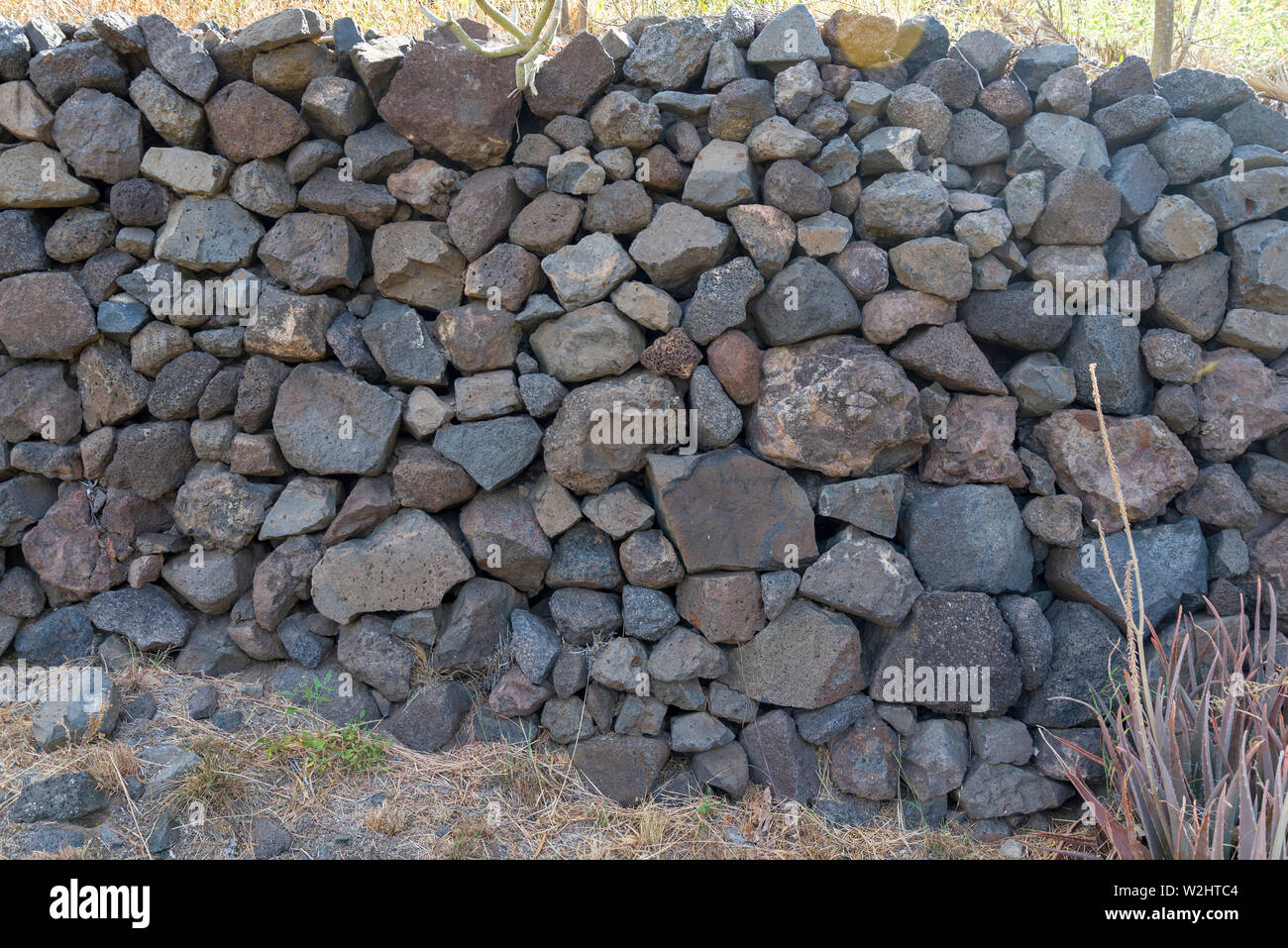 Textur von Steinen und Kopfsteinpflaster mit scharfen Kanten. Natürliche Steine in der Wand verlegt. Stockfoto