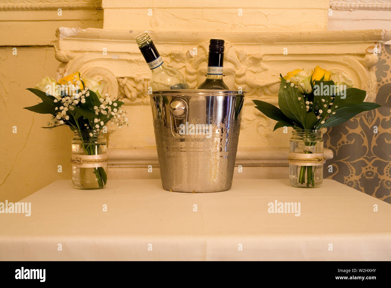 Anzeige von Weinflaschen in Eimer und Blumen in Töpfen bei feierlichen Party zum 50. Hochzeitstag ist ein Paar. Stockfoto