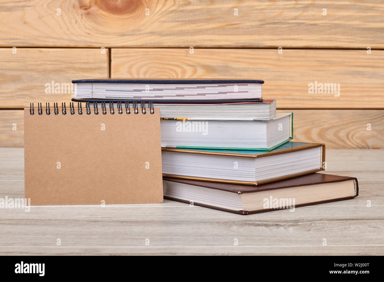 Notizblock und Bücher auf Holzhintergrund. Stockfoto