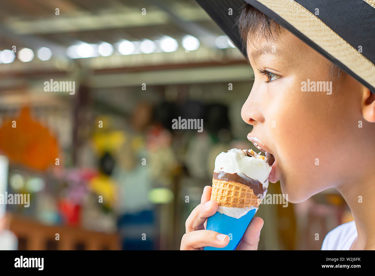 Asiatische Boys einen Hut tragen, essen Eis in der Hand. Stockfoto